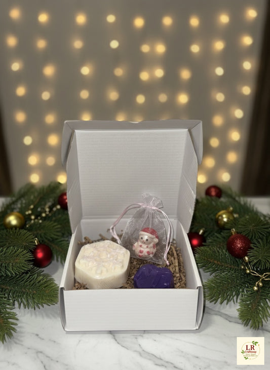 Handmade Christmas soap gift set in white box with holiday decorations.